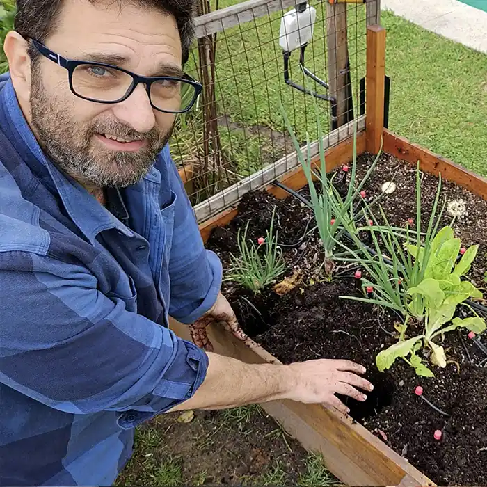 Gabriel trabajando en el invernadero un día de lluvia, junto a plantines